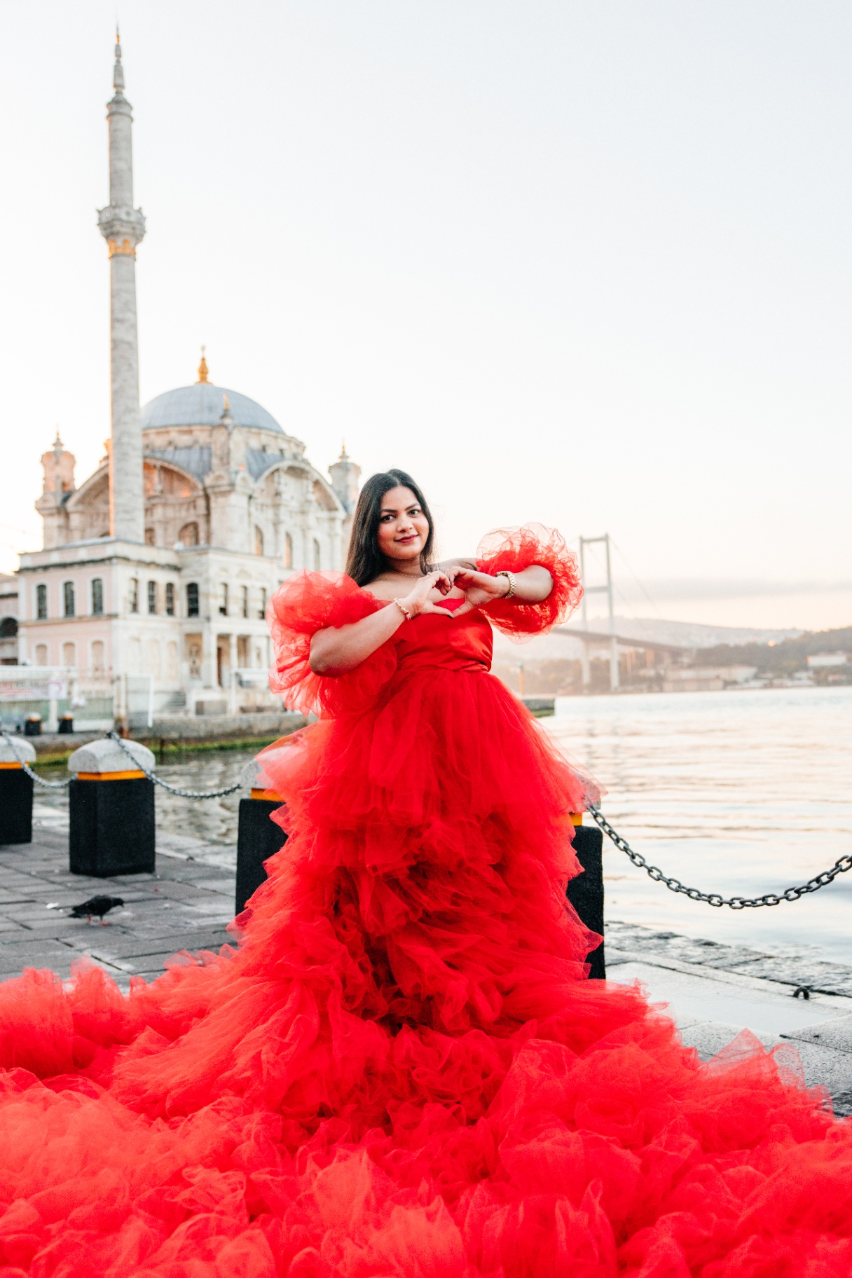 Jyoti forming a heart in a red gown